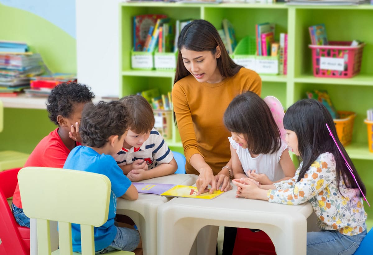 Preschoolers learning with an Asian teacher at a preschool & child care center Serving Smithfield, RI.