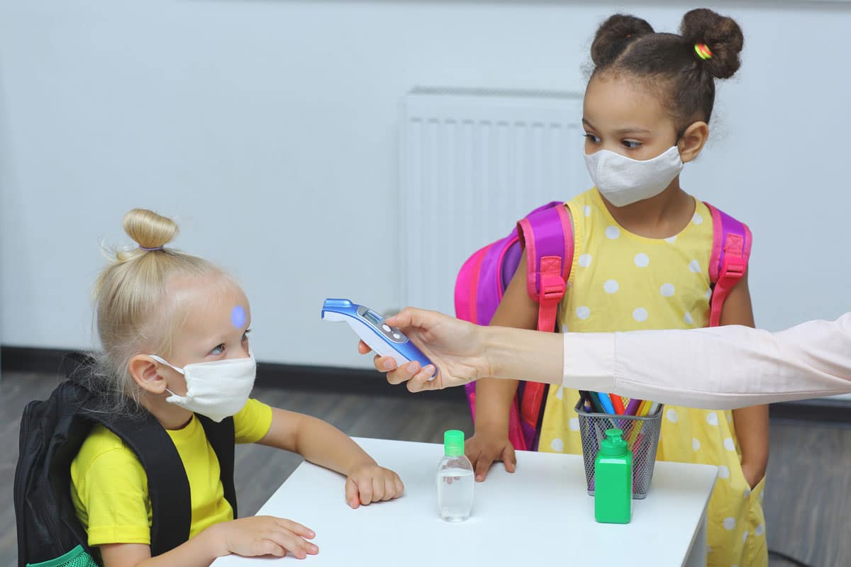 Caucasian preschooler having her temperature checked at a preschool & child care center Serving Smithfield, RI.